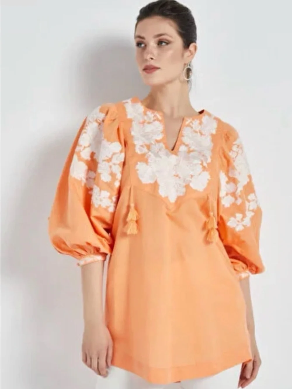 Blouse features split neckline with ties and voluminous embroidered puff sleeves